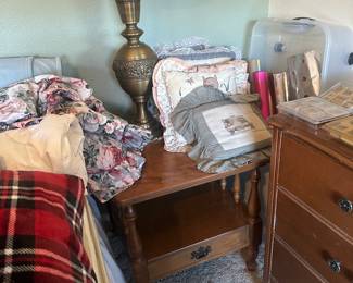 One of two side tables used here as a nightstand and  Tall brass metal work lamp