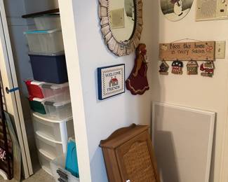 so many storage containers, nice Oval mirror, wall cabinet with a lower shelf and early American decor in many places