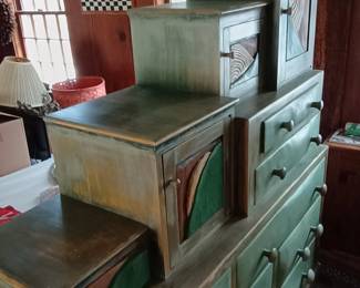Drawers have hand-carved faces depicting the sun rising