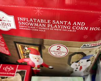 Inflatable santa and snowman playing corn hole