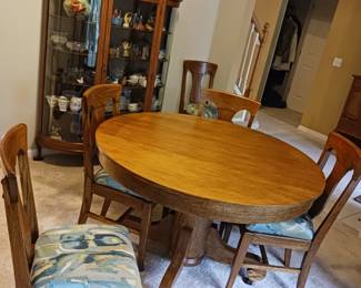 Antique oak dining table with chairs and several leaves