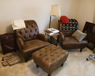 Pair of tufted leather chairs with ottomans
