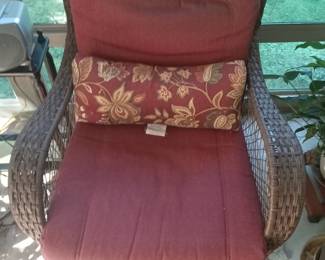 One of two matching wicker chairs with matching rugs