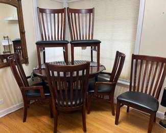 very nice 40" round dark wood table, shown with a 10" leaf inserted with one additional 10" leaf available + 6 chairs