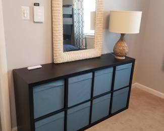 Storage credenza; wicker mirror; table lamp