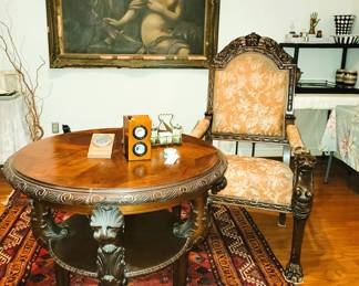 Highly carved round table and chair on antique rug