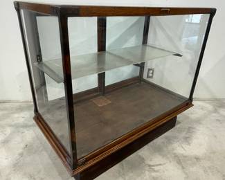 H. A. Heimann Oak Glass Display Case on Pedestal Base with Beveled Glass Top and Double Sliding Doors, Glass Shelf.