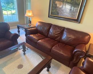 Rich brown leather sofa with rolled arms and nailhead trim. Comfortable seating with a timeless classic look. Shows light wear consistent with use but in very good overall condition.