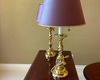 Pair of Brass Spiral Candlestick Table Lamps
Elegant pair of solid brass table lamps with a spiral twist candlestick column and round base. Each lamp features a pull-chain socket and is topped with a burgundy tapered shade trimmed in brass.