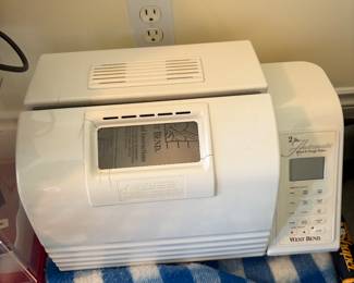West Bend bread machine with digital display. Makes up to 2-lb loaves and includes multiple baking and dough settings. White finish with vented lid and viewing window.