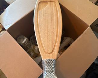 Unique wood serving board with detailed fish head and tail cast in silver-tone metal. Perfect as a charcuterie or appetizer tray with coastal cottage or lodge décor.