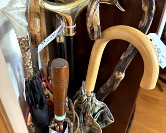 Assorted vintage and antique walking sticks and umbrellas.