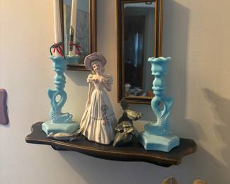 . . . satin-glass fish-themed candle holders with figure between them and accent mirrors behind