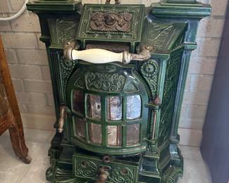 Green enameled cast iron heating stove, likely from the late 19th century or early 20th.