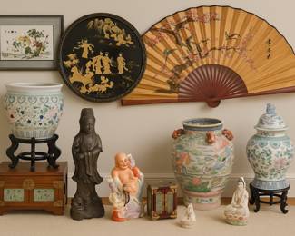 Step into a room where elegance meets storytelling! This collection of Asian-inspired treasures includes everything from a lacquered wall plaque with golden figures that looks like it came straight from an imperial palace, to a giant fan that could cool down an emperor (or at least make your neighbors jealous). Weâve got porcelain vases painted with cranes, lotus blossoms, and mythical beastsâbecause plain vases are for amateurs. Add in serene deities, a laughing Buddha surrounded by kids (heâs clearly the babysitter of the century), and embroidered silk art alive with birds in flight. Together, itâs a gallery of grace, charm, and just enough mystique to make your living room feel like it should start charging admission.