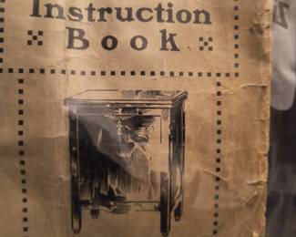 Original instruction book for sewing machine in cabinet