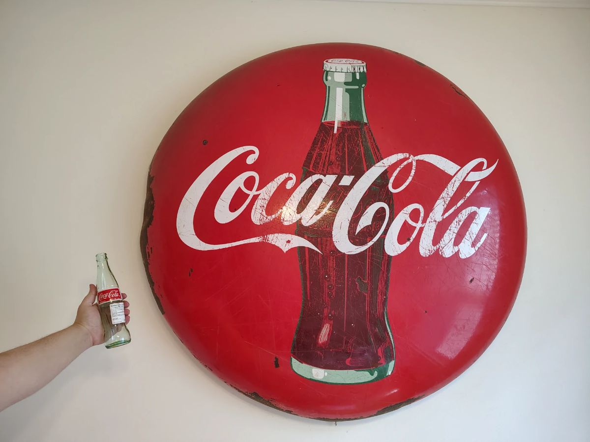 Huge coca cola button sign .
