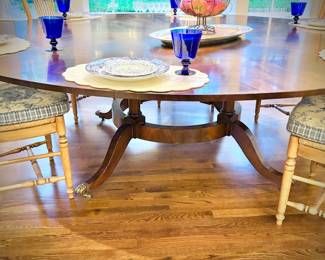 Antique mahogany round dining table with brass clawed feet. This table has leaves on the OUTSIDE of the table - remove them to make the table smaller. Leaves are numbered to ensure the wood grain matches up.