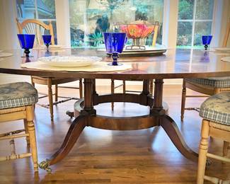 Antique mahogany round dining table with brass clawed feet. This table has leaves on the OUTSIDE of the table - remove them to make the table smaller. Leaves are numbered to ensure the wood grain matches up.