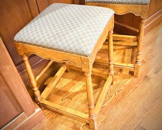Two wood stools with upholstered seats