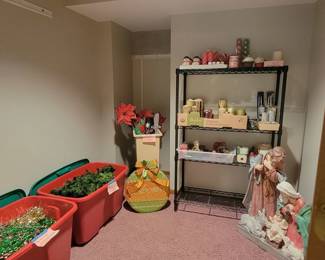 Outdoor Christmas decorations including metal yard decorations, a nativity, and a deer. Garland, poinsettas, fake flowers