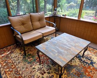 This casual patio set features sturdy metal frames paired with soft cloth cushions for relaxed comfort. The stone-top table is durable yet inviting, it’s perfect for laid-back outdoor living.