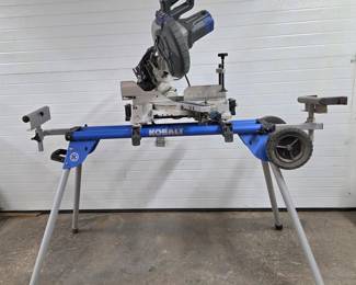A Kobalt 10-inch Compound Miter Saw with Stand, designed for precision cutting of wood, trim, and other materials. Features a powerful motor, adjustable cutting angles for bevel and miter cuts, a durable 10-inch blade, and comes mounted on a sturdy, portable stand for stability and convenience. Ideal for both professional and DIY projects.