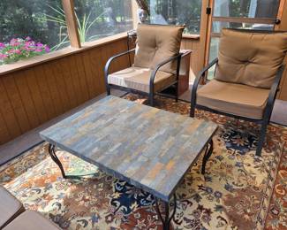 This casual patio set features sturdy metal frames paired with soft cloth cushions for relaxed comfort. The stone-top table is durable yet inviting, it’s perfect for laid-back outdoor living.