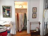 vintage bedding hanging in closet, unusual quilt rack with storage box