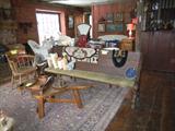 Church pew with cushion, hooked rugs, firehouse chair, coffee table made from blacksmith bellows