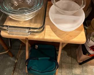 Living room side of divider - set of clear bowls, divided server, clear bow 7 2 large baking dishes on TV tray (1) with miscellaneous carrier on floor