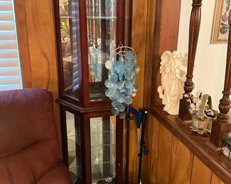 Living room - curio cabinet, glass jar - shelf on right holds more collectibles