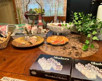 Dining room table containing sets of salt shakers, miscellaneous platters and more!