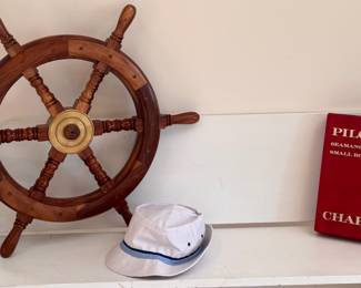 Wooden ships wheel and other nautical items on vintage bench