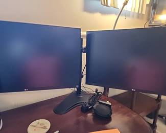 LG dual monitors on a stand with a speaker
