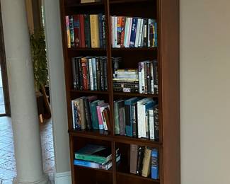 Tall cherry wood bookcase… full of all types of books! Travel, fiction, biographies, and more!