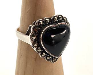 Sterling Silver size 9 ring with black heart at the center surrounded by a filigree design with marcasite stones accenting. 6.48 gtw.