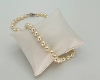 18" individually knotted pearl necklace with gold colored clasp, no markings. Cannot authenticate.