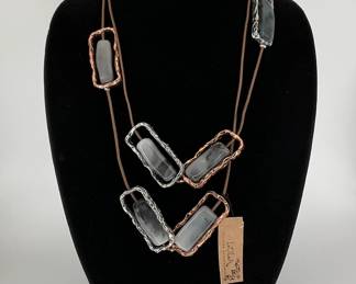 43" long fashion necklace featuring copper tone and silver tone accents with black and white stones. Appears new.
