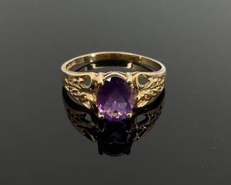 Oval cut 7.8 mm x 6.8 mm amethyst center stone on a 10K gold size 10 ring. Stamped "10K". 2.59 gtw.