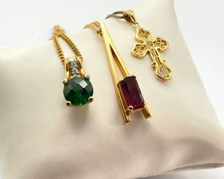 Three (3) vintage fashion necklaces: Avon with a purple stone on a 22" chain, gold tone cross on an 18" gold tone silver (925) chain, green stone pendant on a gold tone 24" chain.