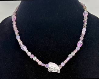 18" necklace featuring amethyst beads throughout with a larger quartz at the center. 27.89 gtw.