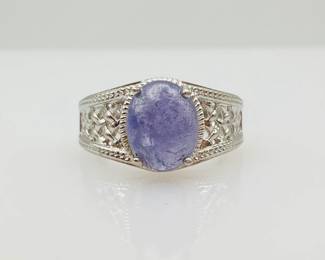 Sterling silver ring with a lattice design on the band featuring a 10mm x 8mm 3.75 ct tanzanite cabochon at the center. 4.56 gtw. Size 7.25. Includes certificate provided by consigner.