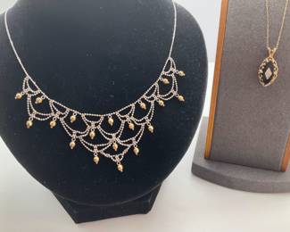 14K gold 15" chain with a 1" pendant with a small diamond at the center. 2.33 gtw. Silver tone and gold tone 16" apron necklace.