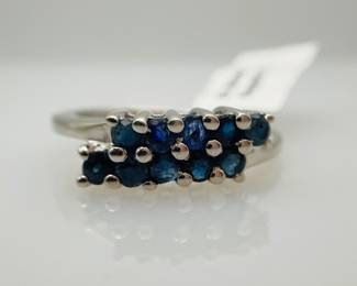 Ten (10) prong set 2.5mm dark blue round sapphires are set in 2 rows on this size 7 sterling silver ring. Stamped "925". Approximate weight of sapphires 0.8 ctw. 2.78 gtw. Includes certificate provided by consigner.