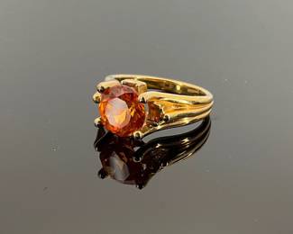 Round cut 1mm orange sapphire set in a gold plated sterling silver size 10 ring. Ring is stamped "925". 7.73 gtw.