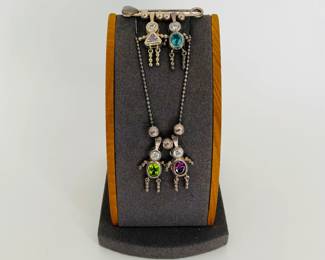 Necklace and Pin with people charms (3 boys, 1 girl) each featuring a birthstone colored tourmaline. Pin and 23" necklace chain are both stamped 925.