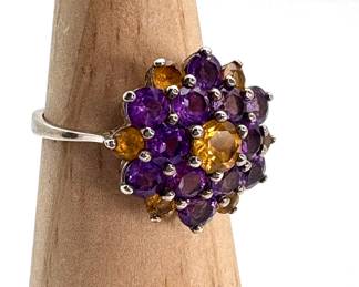 Round cut amethyst and citrine stones create a flower pattern on this size 9.5 sterling silver ring. Stamped 925. 4.84 gtw.