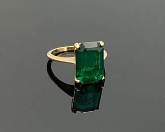 A bright green 13.8 mm x 10.2 mm emerald cut tourmaline sits in an 18K gold plated size 7.5 ring. 4.0 gtw.