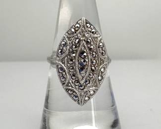 This adjustable sterling silver ring features a filigree type pattern accented with sparkling marcasites throughout. One stone is missing. 6.3 gtw.